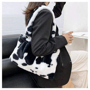 Dettaglio della borsa tote morbida in peluche maculata bianco e nero con anello in metallo