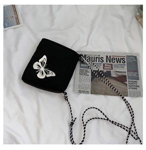 Detailed view of black nylon crossbody phone bag with reflective silver butterfly print