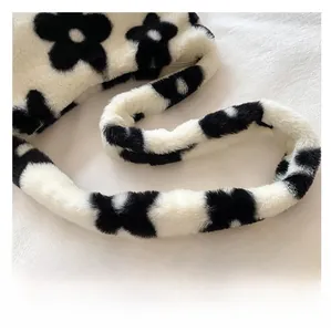 Gros plan sur la bandoulière en fausse fourrure pelucheuse de ce sac à fleurs