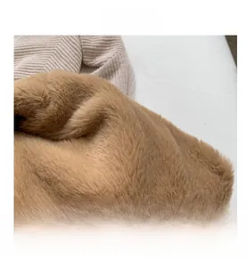 Vue macro de la texture en fausse fourrure caramel avec maille côtelée sur le grand sac