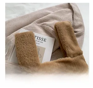 Gros plan sur la texture en fausse fourrure marron et les coutures de l'anse du sac
