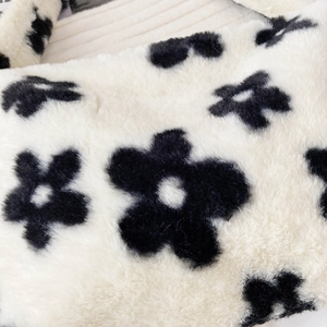 Vue détaillée d'un sac en fausse fourrure pelucheuse avec motifs floraux noirs et beige