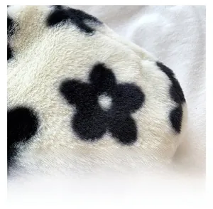 Gros plan détaillé montrant la texture douce de la fausse fourrure et le motif vache