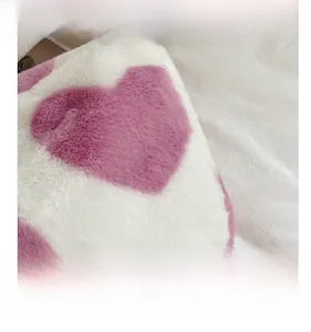 Detailansicht aus weichem weißem Plüsch mit rosa Herzmustern auf der Schultertasche