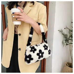 Detalle de bolso de peluche con estampado de flores en blanco y negro y piel sintética