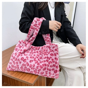 Dettaglio della borsa tote in ecopelliccia leopardata rosa indossata da una modella elegante