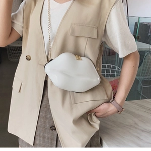 Chic white lip-shaped crossbody bag with gold chain strap shown on a female model