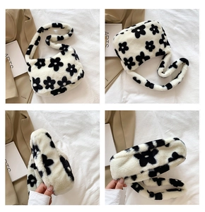 Vue détaillée du sac à bandoulière en peluche avec motif de vache et fleurs noires