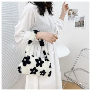 Bolso de hombro de felpa con patrón floral en blanco y negro en una modelo