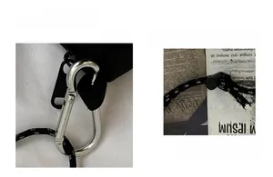 Detail of black crossbody bag showing silver carabiner and reflective woven cord