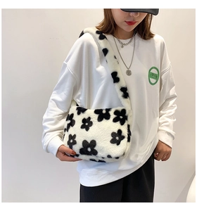 Détail du sac à bandoulière en peluche avec motifs floraux noirs sur fausse fourrure
