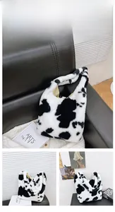 Detailed views of the white cow pattern plush handbag on a black leather sofa