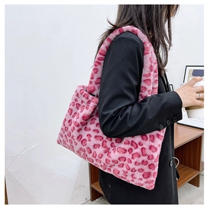 Dettaglio della borsa tote in pelliccia sintetica maculata rosa indossata con blazer