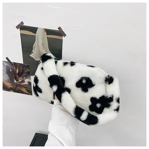 Primer plano de bolso de hombro de felpa con estampado floral en blanco y negro