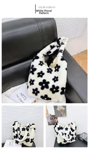 Close-up of white plush tote bag with black flower patterns on a stylish leather sofa