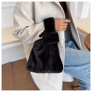 Détail d'un sac cabas en fausse fourrure noire avec texture douce et poignée unique