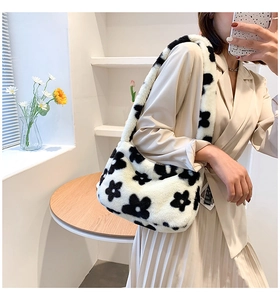 Détail d'un sac sous les bras en fausse fourrure pelucheuse avec motif floral noir chic