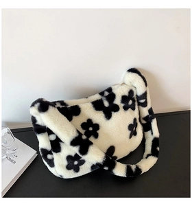 Vue détaillée montrant la texture douce en peluche et le motif floral noir du sac à bandoulière