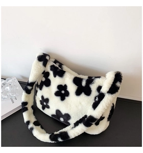 Détail du sac à bandoulière en peluche avec motif floral noir et fermeture éclair