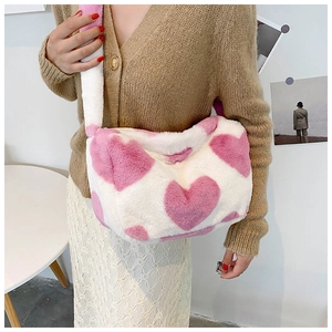 Detail der weichen weißen Plüsch-Baguette-Tasche mit leuchtend rosa Herzmustern