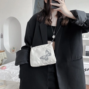 White casual crossbody bag featuring a reflective butterfly print and slim black strap