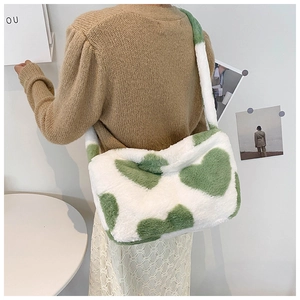 Detailansicht der flauschigen Faux-Fur Baguette-Tasche mit grünem Herzmuster
