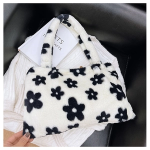 Dettaglio della borsa tote in peluche con motivo floreale bianco e nero e manico morbido