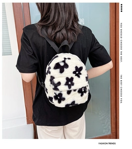 Gros plan du motif de fleurs noires et blanches sur le sac à dos en peluche douce