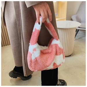 Gros plan sur le sac à main en peluche rose et blanc à motif vache et texture douce