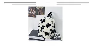 Détail d'un mini sac à dos en peluche à motif floral noir et blanc avec poignée