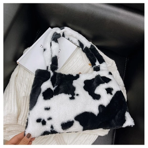 Dettaglio della consistenza pelosa con stampa mucca e del manico morbido di questa borsa tote