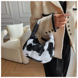 Détail du sac à bandoulière en peluche à motif vache sur un mannequin en veste beige