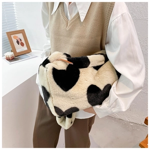 Detailaufnahme einer flauschigen cremeweißen Baguette-Tasche mit schwarzen Herzen