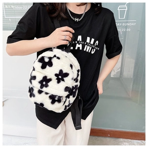 Gros plan du sac à dos en peluche duveteuse avec motifs floraux noirs sur fausse fourrure