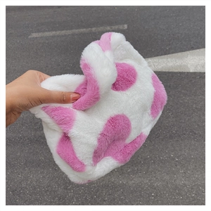 Gros plan sur la texture douce en fausse fourrure rose et blanche d'un sac bandoulière