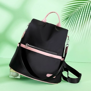 Detail view of water-resistant nylon backpack with stylish pink accents and side pockets