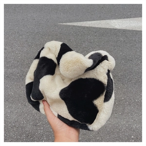 Détail de la texture en fausse fourrure douce et du motif cœur sur le sac seau imprimé vache