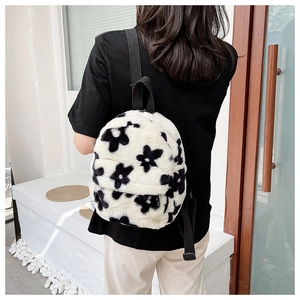 Détail du sac à dos en peluche à motif de fleurs noires et blanches avec texture douce