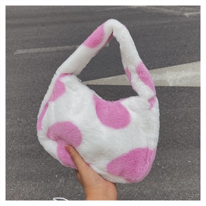 Gros plan détaillé du sac hobo en peluche avec motif de vache rose et texture douce