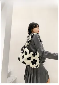 Détail du sac à bandoulière en peluche blanche à motif floral sur un mannequin femme