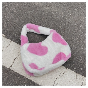 Détail de la texture pelucheuse d'un sac à main rose et blanc à motif de vache