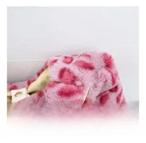 Detail of pink leopard faux fur handbag showing soft texture and gold snap button closure