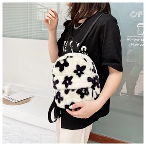 Détail du sac à dos en peluche douce à motif floral noir et blanc avec fermetures
