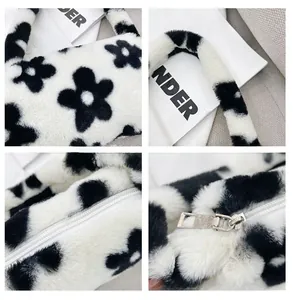 Detalle del bolso de hombro de felpa con estampado floral y cierre de cremallera metálica