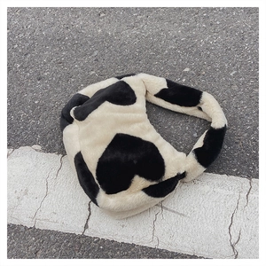 Détail de la texture en peluche du sac seau à motif de cœurs noir et blanc