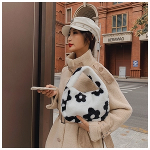 Détail du sac à main en peluche noir et blanc avec de grands motifs floraux pour l'automne