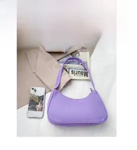 Detailed view of a purple nylon crescent bag on a stylish aesthetic background