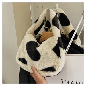 Détail d'un sac hobo en fausse fourrure à motif vache avec une texture douce et élégante