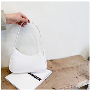 Close-up of a white nylon crescent bag with silver zipper and curved shoulder strap