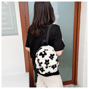 Détail du petit sac à dos en peluche à fleurs noir et blanc avec bretelles réglables